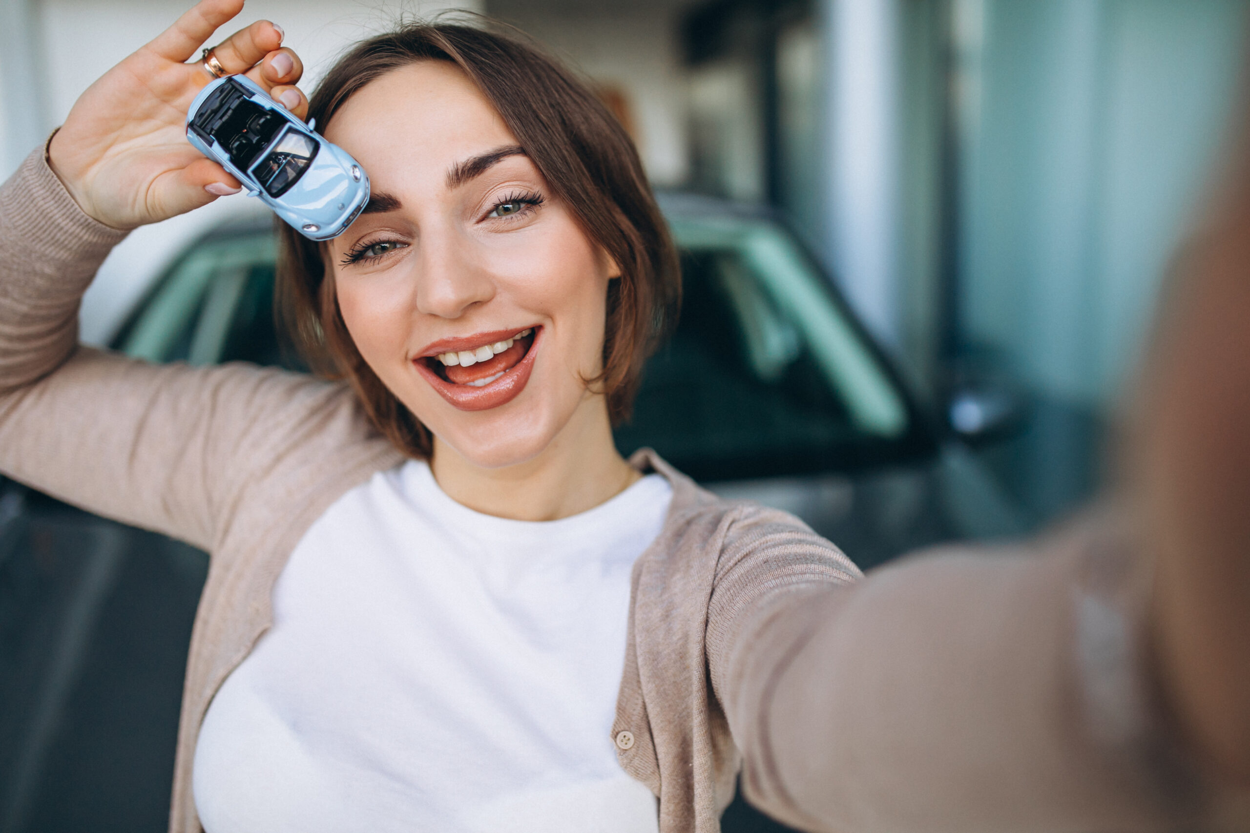 Young pregnant woman choosing a car in a car showroom
