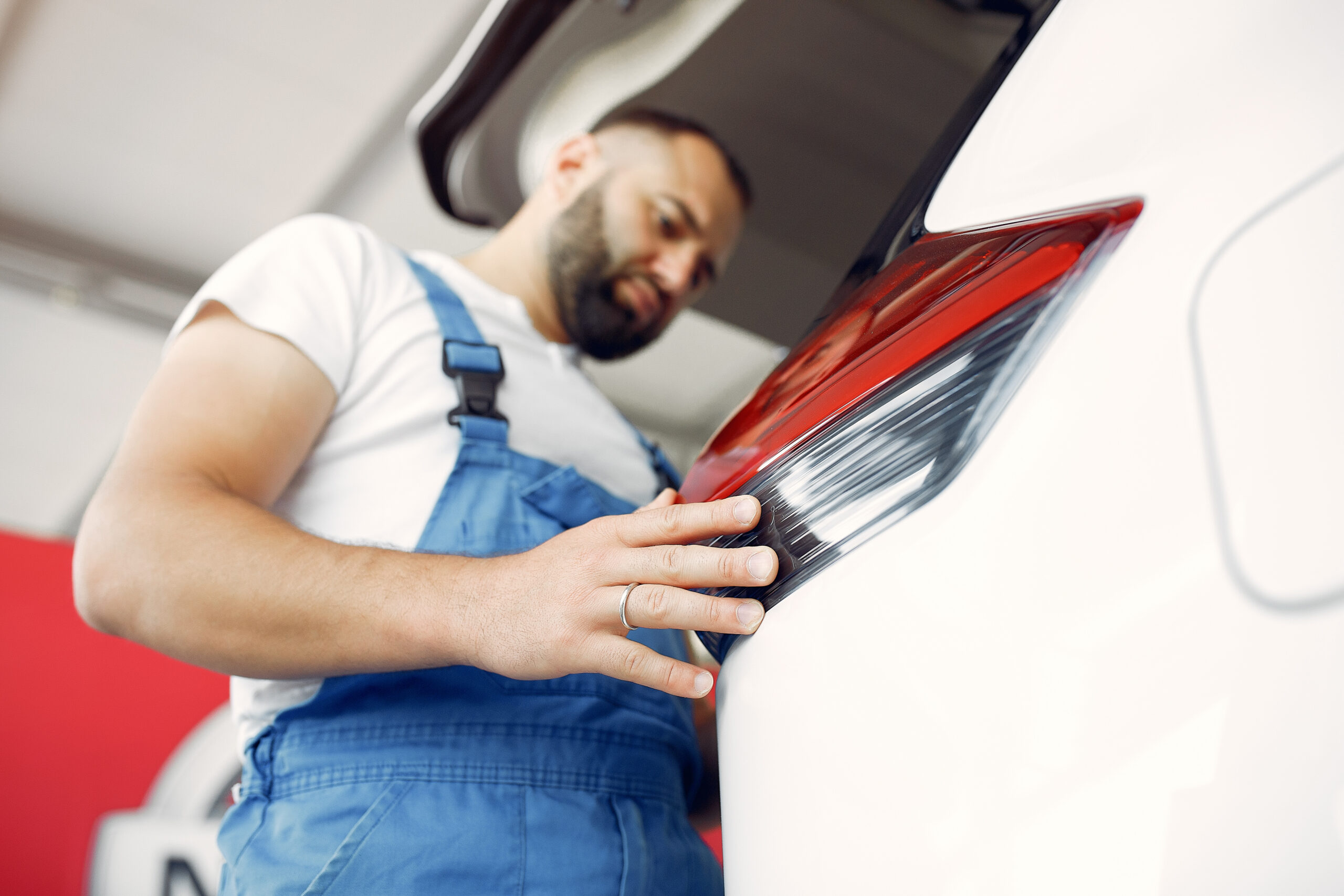 Handsome man in a blue uniform checks the car